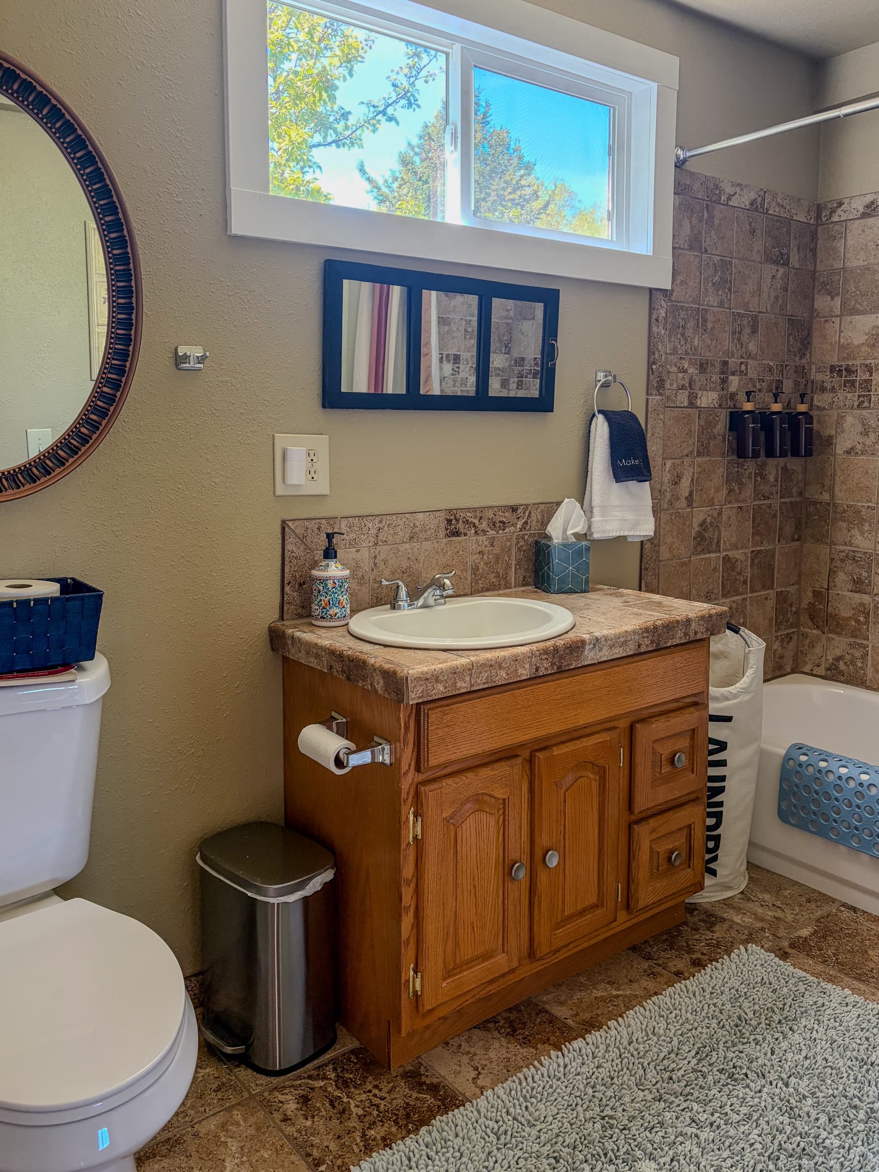 Full bathroom at The Cottage with tile shower, vanity, and natural light